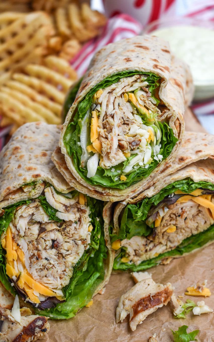 chick fil a chicken cool wraps cut in half and stacked on brown parchment paper