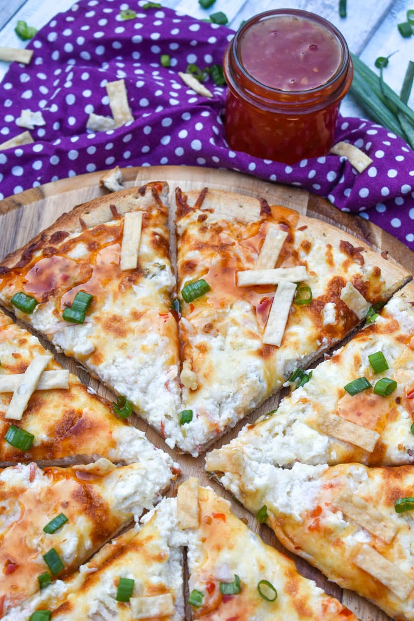 slices of a crab rangoon pizza on a wooden pizza peel