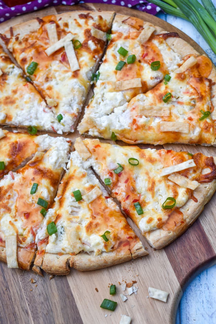 slices of a crab rangoon pizza on a wooden pizza peel