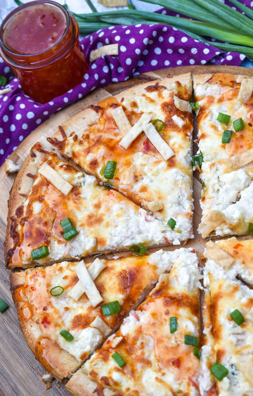 slices of a crab rangoon pizza on a wooden pizza peel