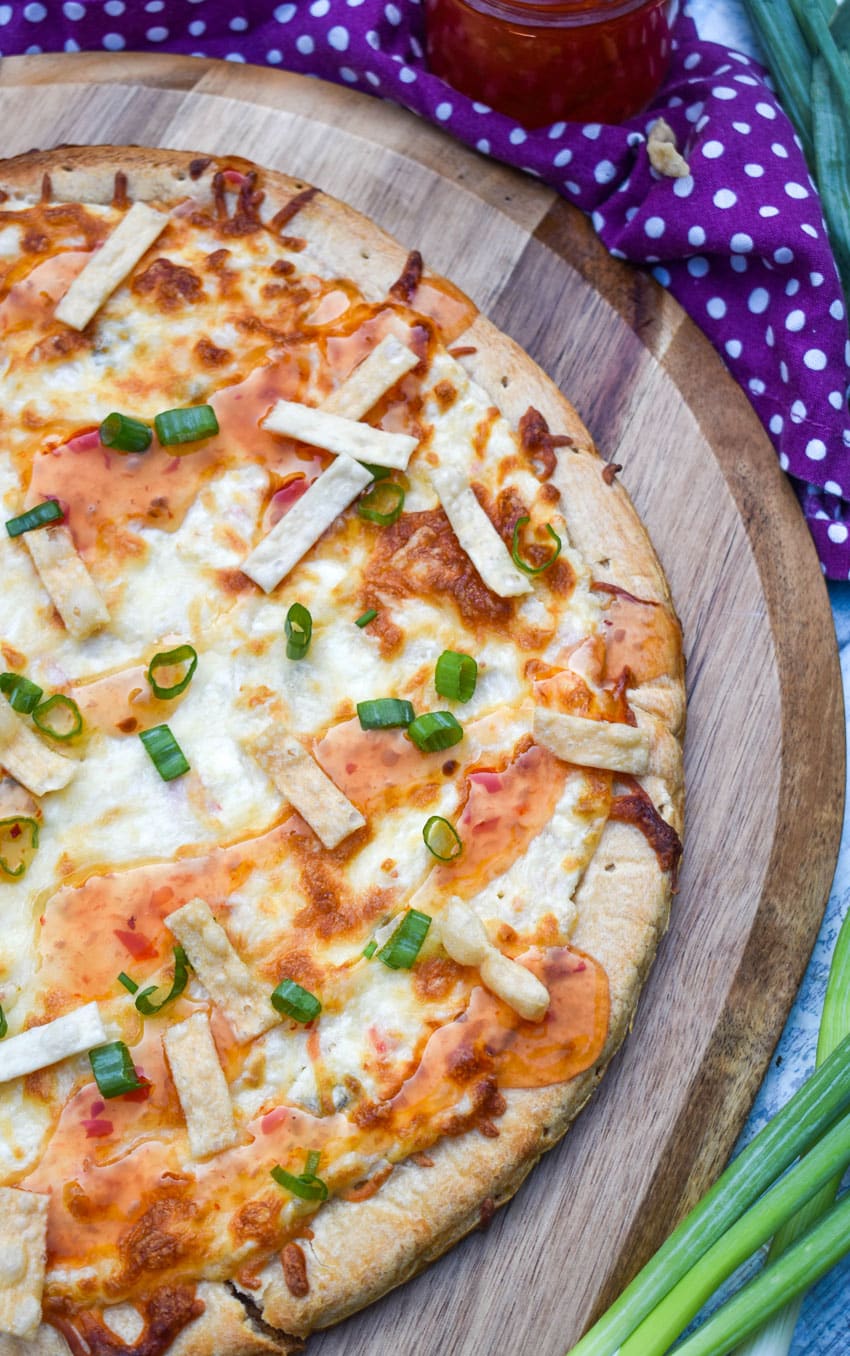 a crab rangoon pizza on a wooden pizza peel