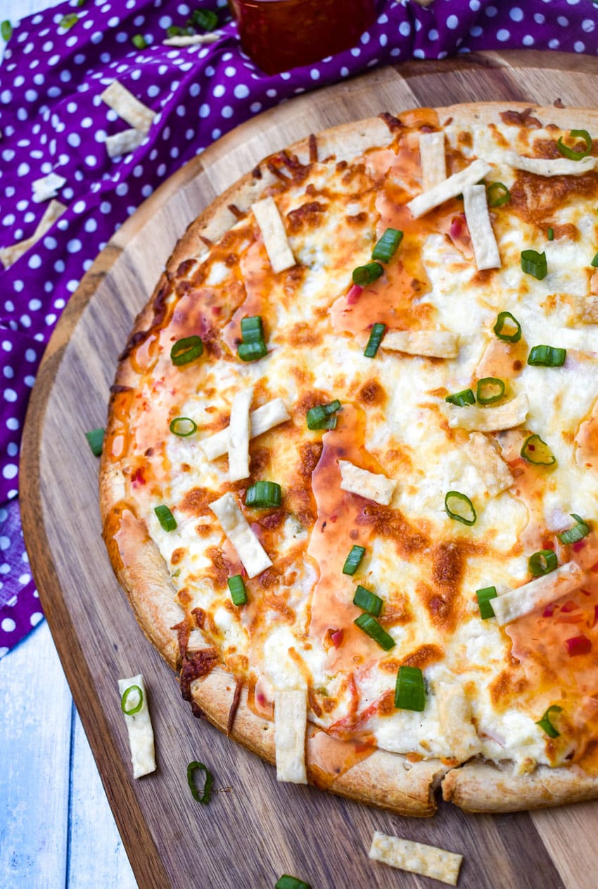 a crab rangoon pizza on a wooden pizza peel