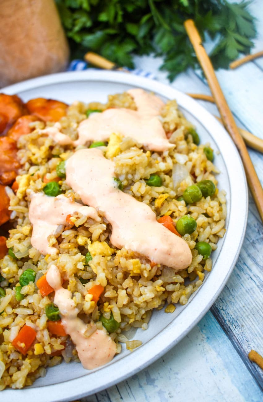 homemade yum yum sauce on fried rice on a small gray plate