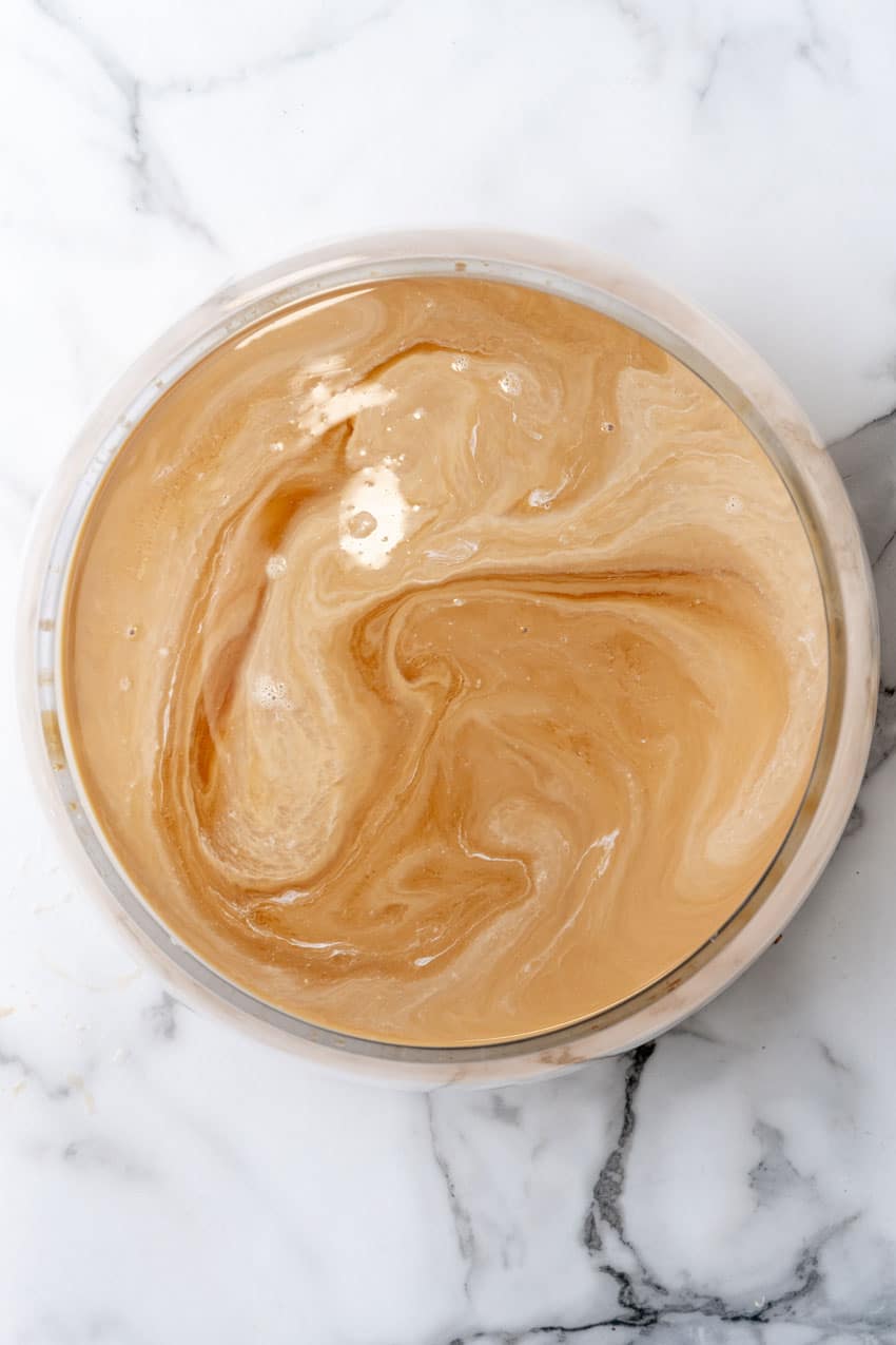 creamed coffee mixed with simple syrup in a glass mixing bowl