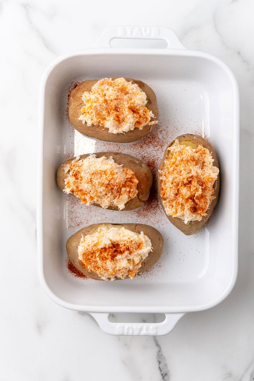 four crab stuffed potatoes in a white baking dish