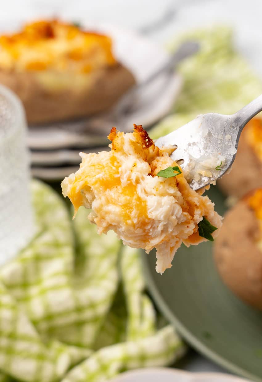 a silver fork holding up a scoop of twice baked crab stuffed potato