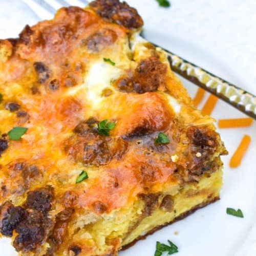 a slice of cheddar bay breakfast bake on a small white plate with a silver fork resting on the side