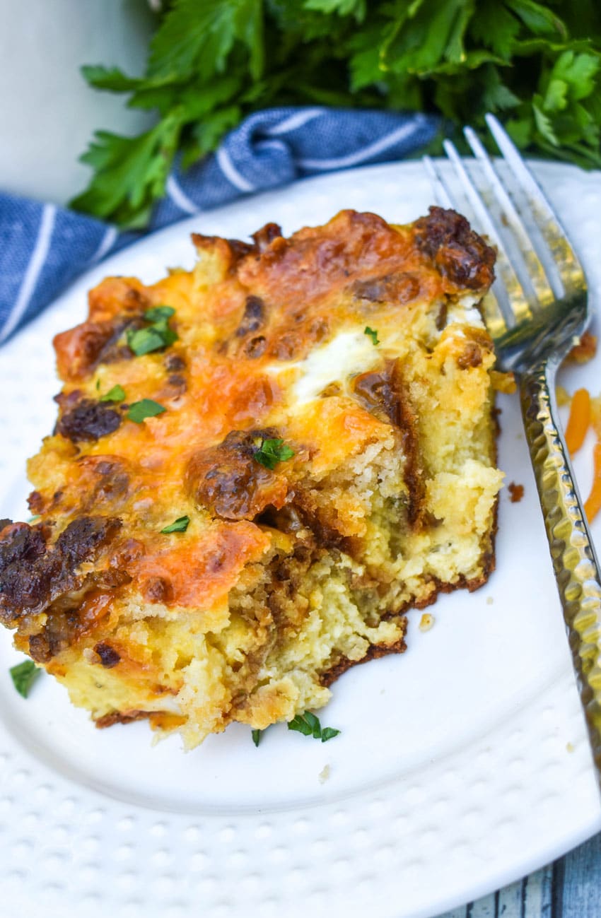 a slice of cheddar bay breakfast bake on a small white plate with a silver fork resting on the side