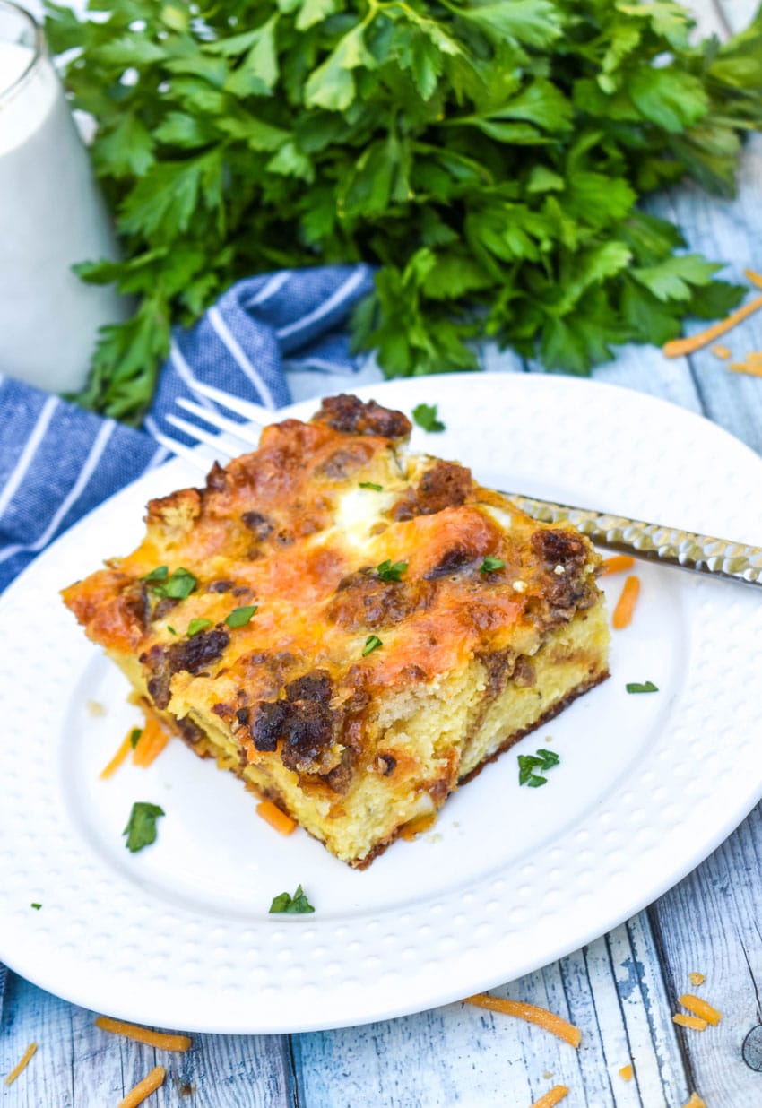 a slice of cheddar bay breakfast bake on a small white plate with a silver fork resting on the side