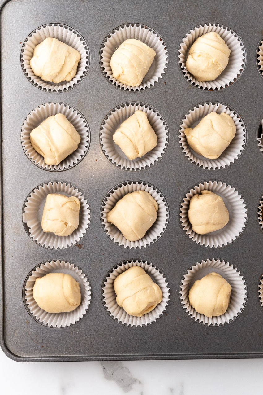 unbaked resurrection rolls in cupcake liners in a metal muffin pan