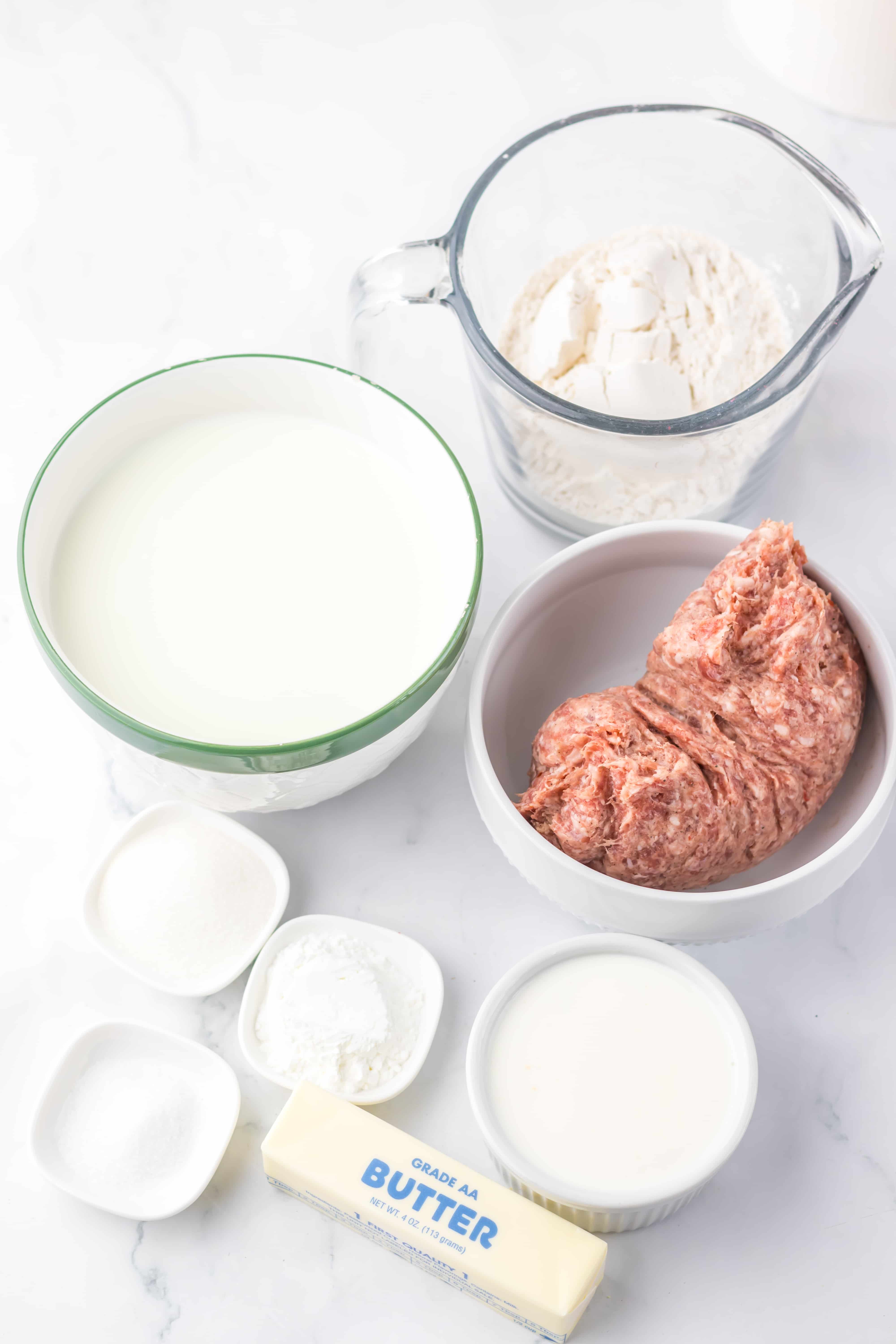 an overhead image showing the measured ingredients needed to make a batch of homemade sausage gravy and fresh country biscuits