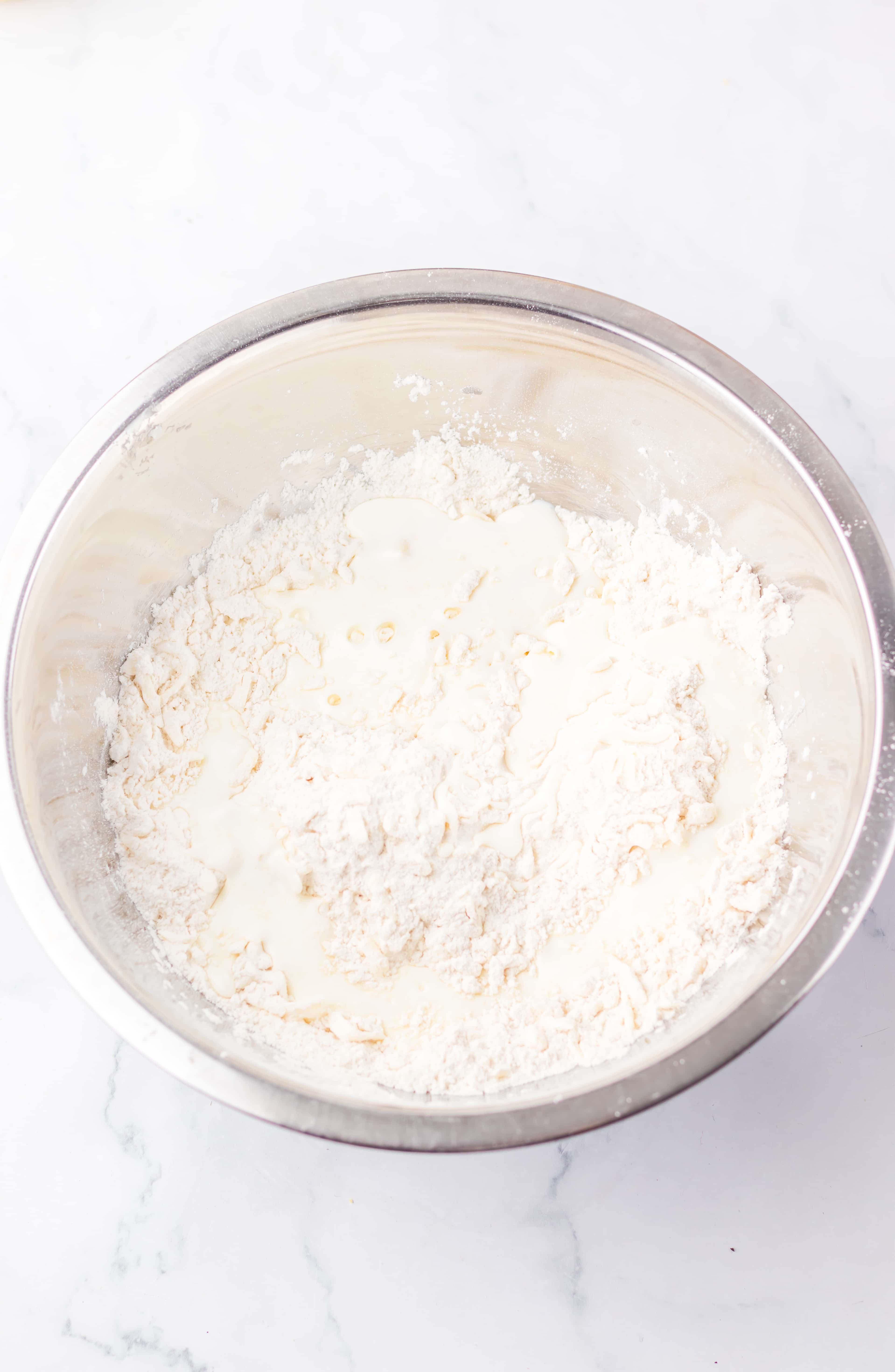 homemade hiscuit batter in a metal mixing bowl