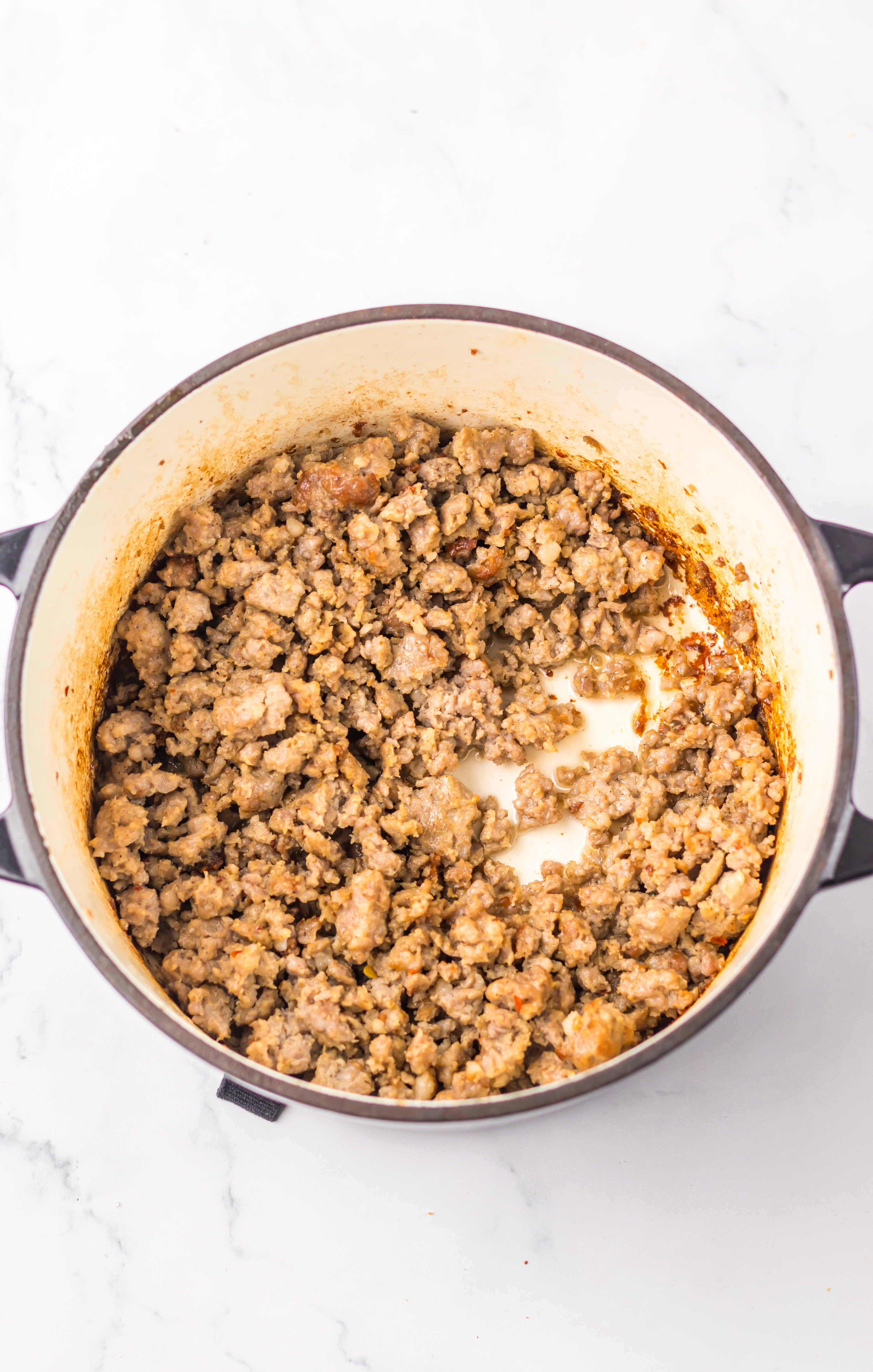 cooked crumbled sausage in a small dutch oven