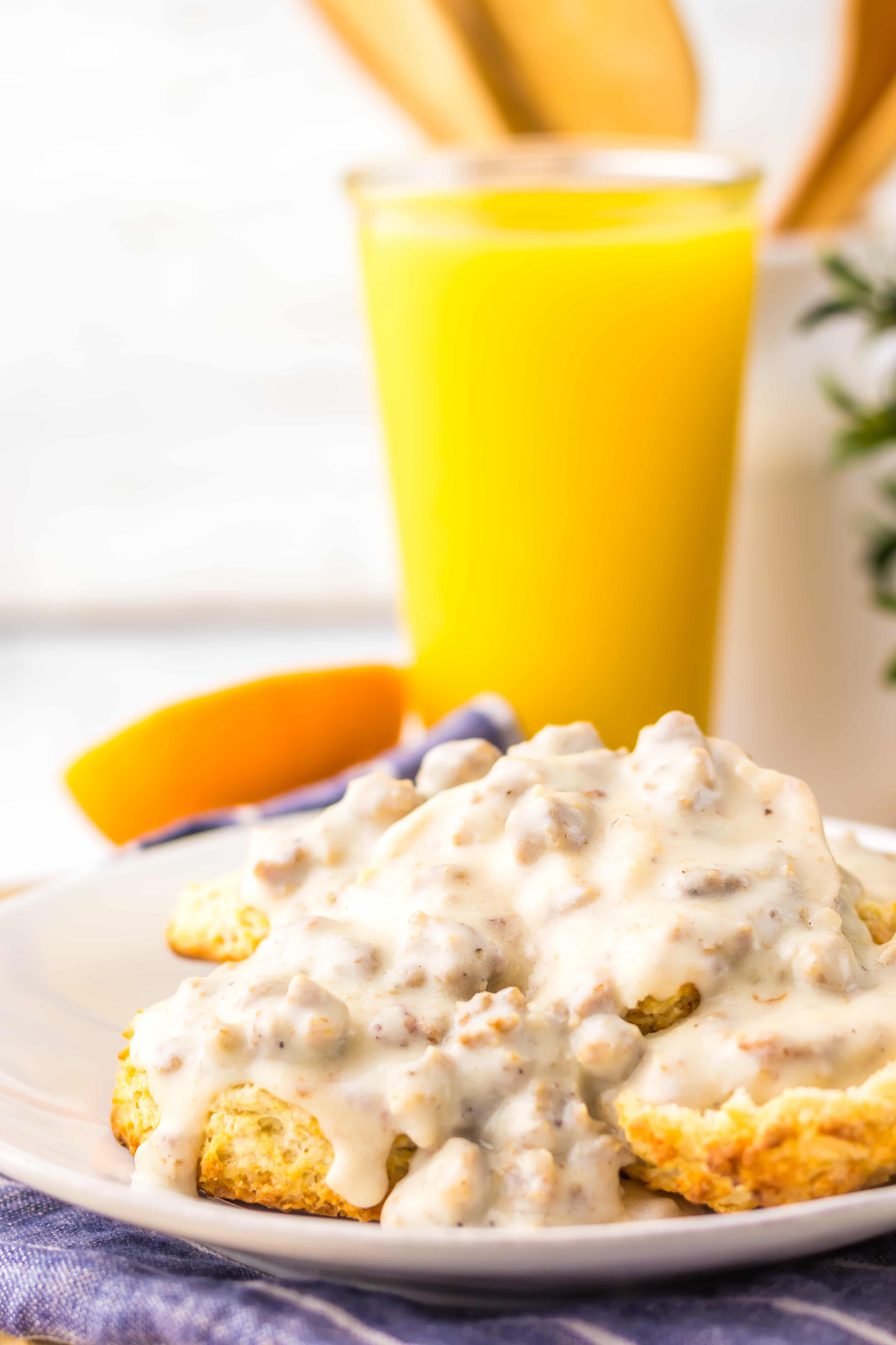 copycat cracker barrel sausage gravy over halved homemade biscuits on a white plate