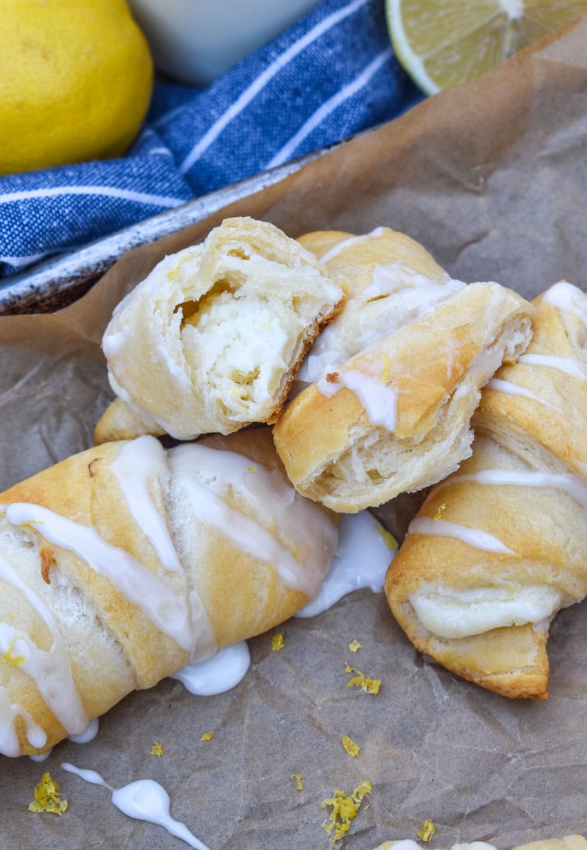 a pile of lemon cheesecake crescent rolls on a parchment paper lined baking sheet