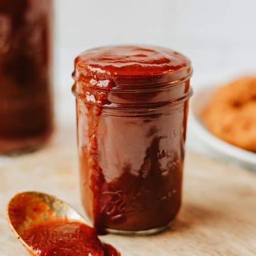 homemade barbecue sauce in a glass jar on a wooden table