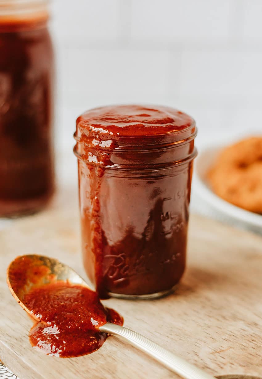 homemade barbecue sauce in a glass jar on a wooden table