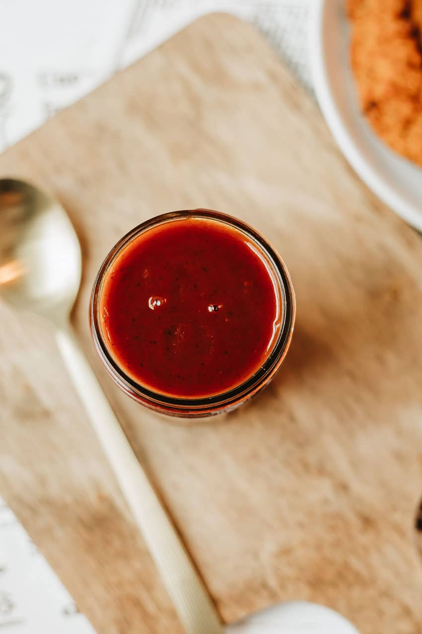 homemade barbecue sauce in a glass jar on a wooden table