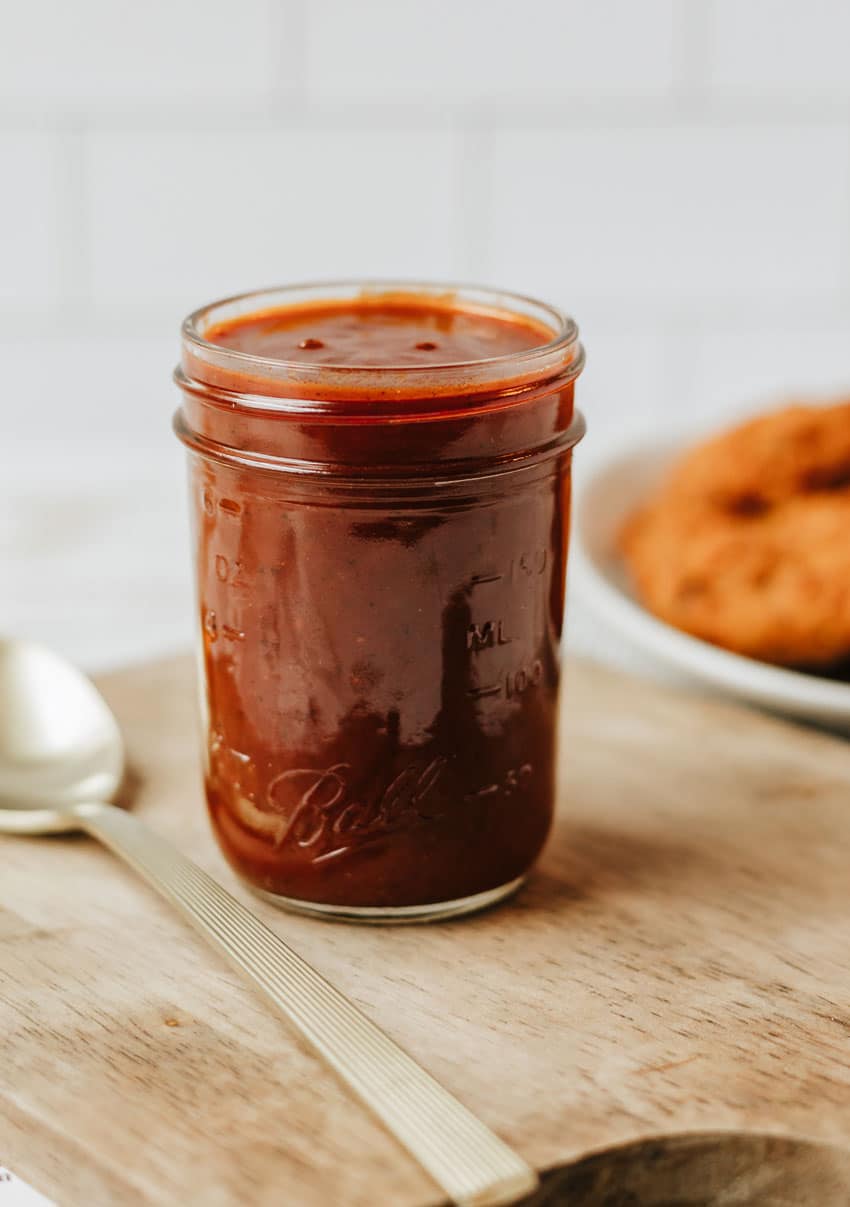 homemade barbecue sauce in a glass jar on a wooden table
