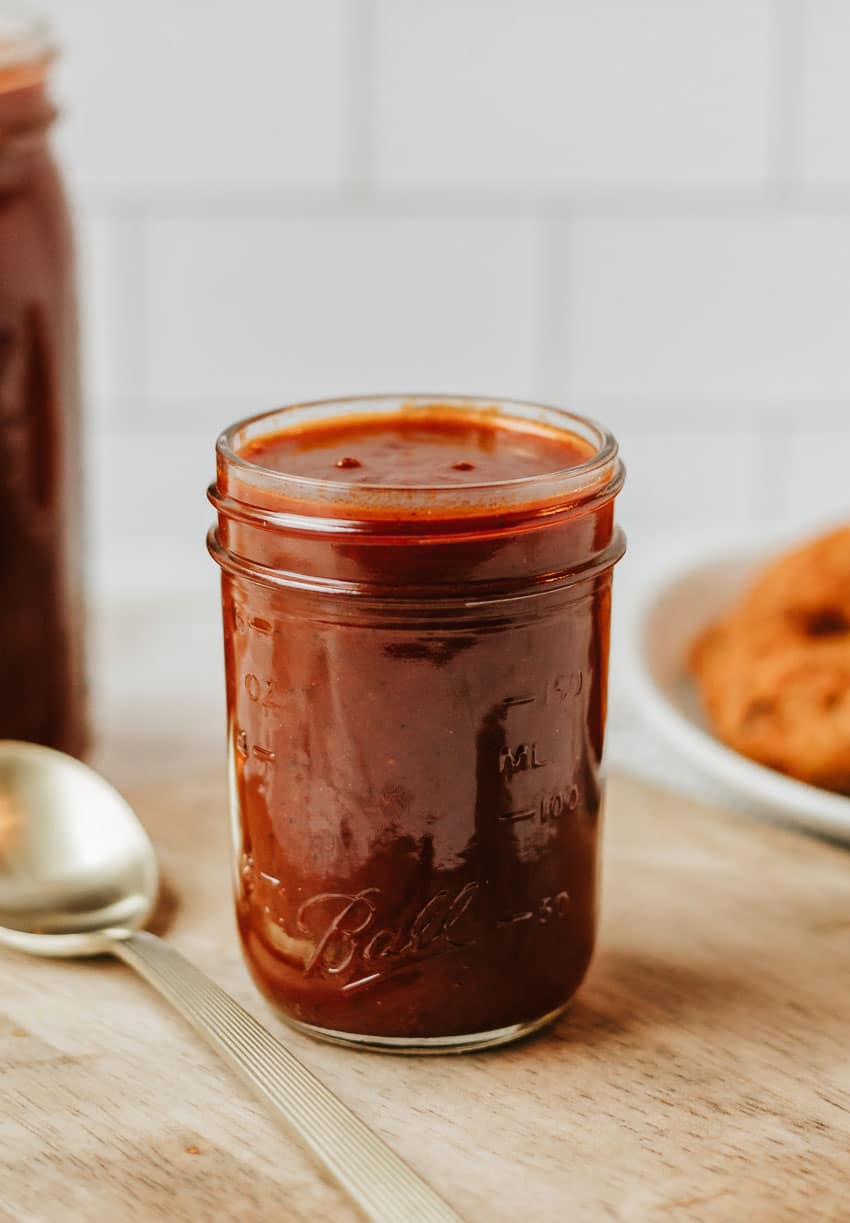 homemade barbecue sauce in a glass jar on a wooden table