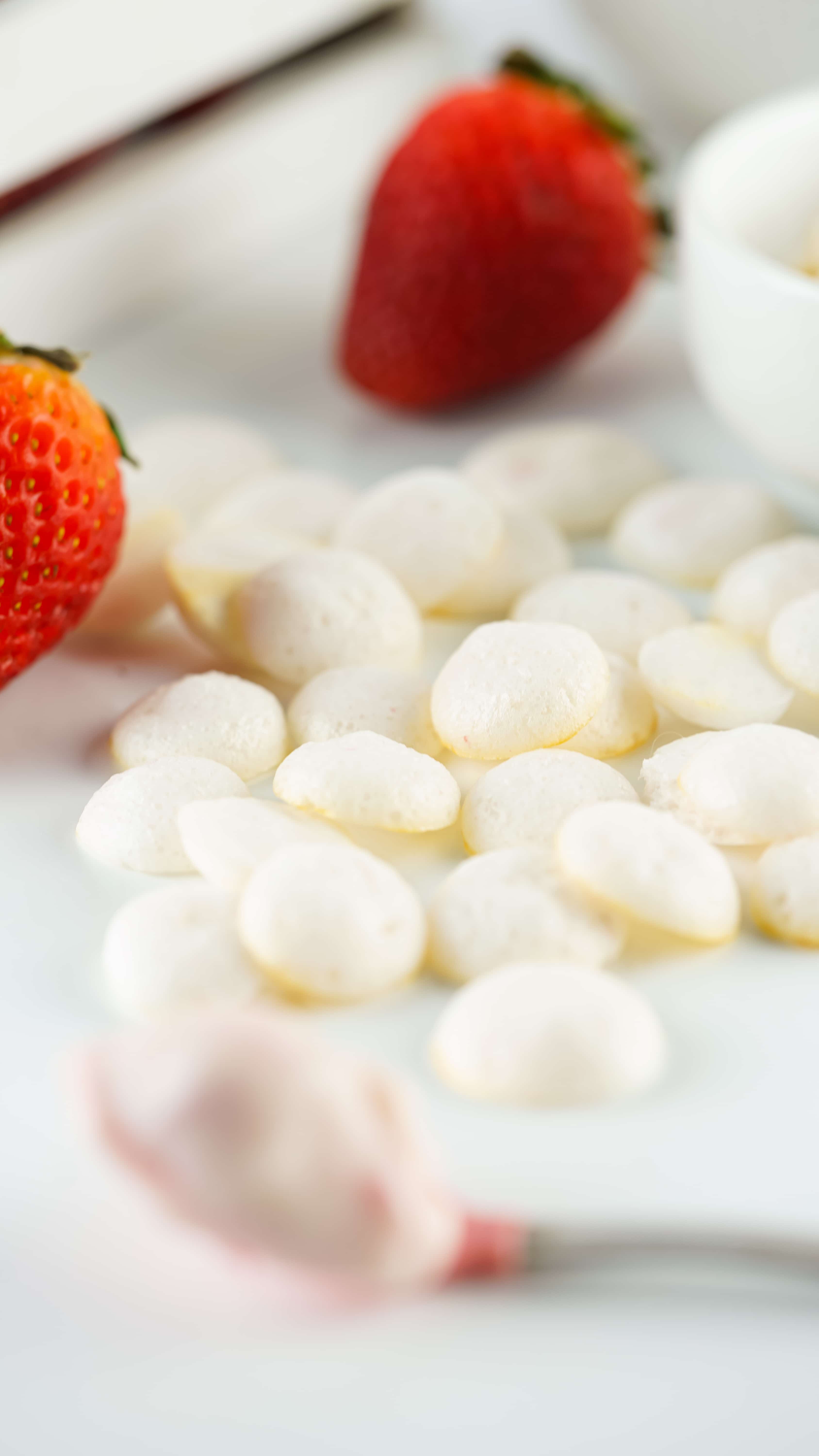 homemade yogurt melts on a wooden table with fresh strawberries in the background