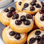 blueberry cream cheese danishes stacked on a blue plate