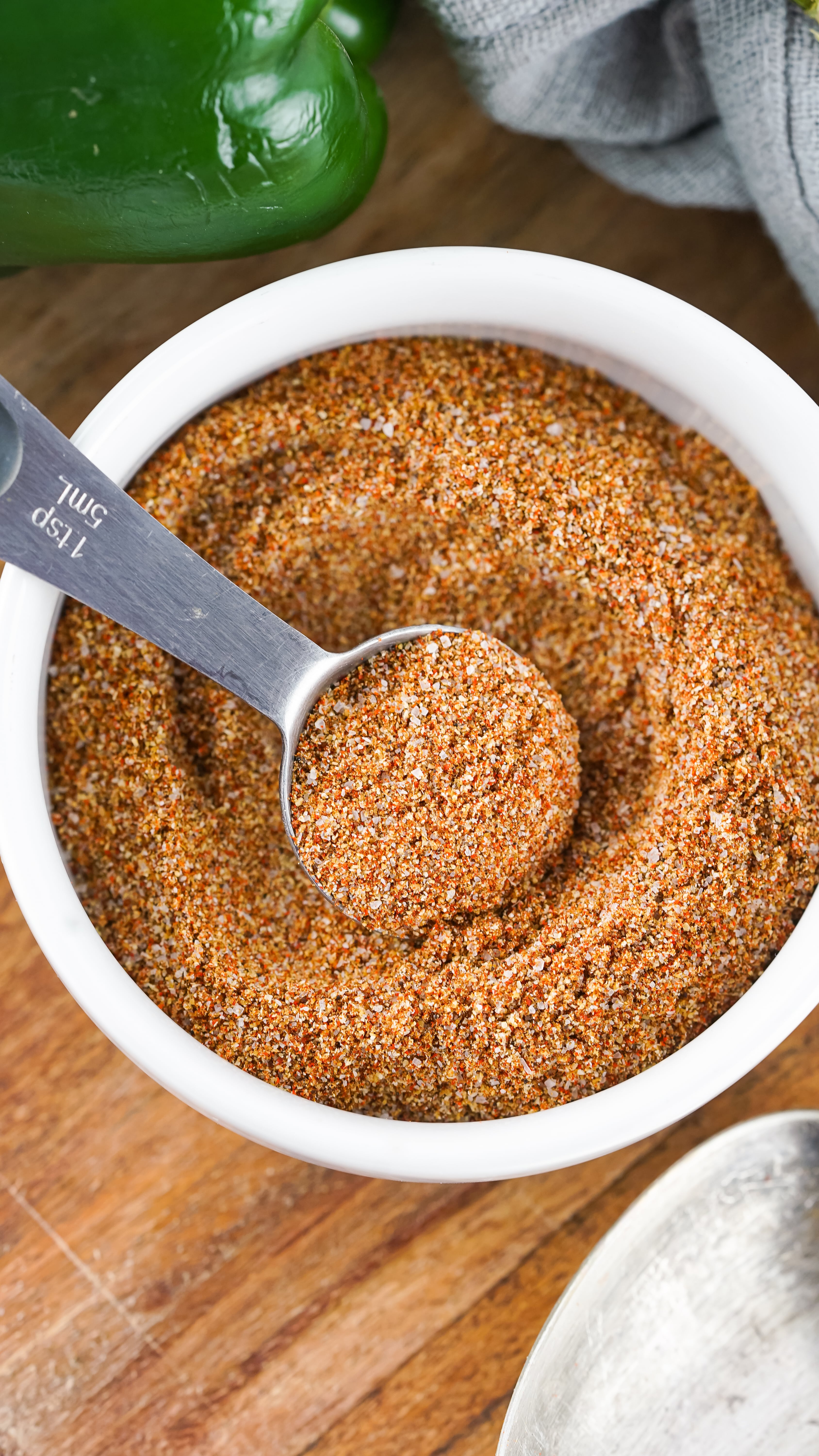 homemade fajita seasoning in a small white bowl on a wooden cutting board