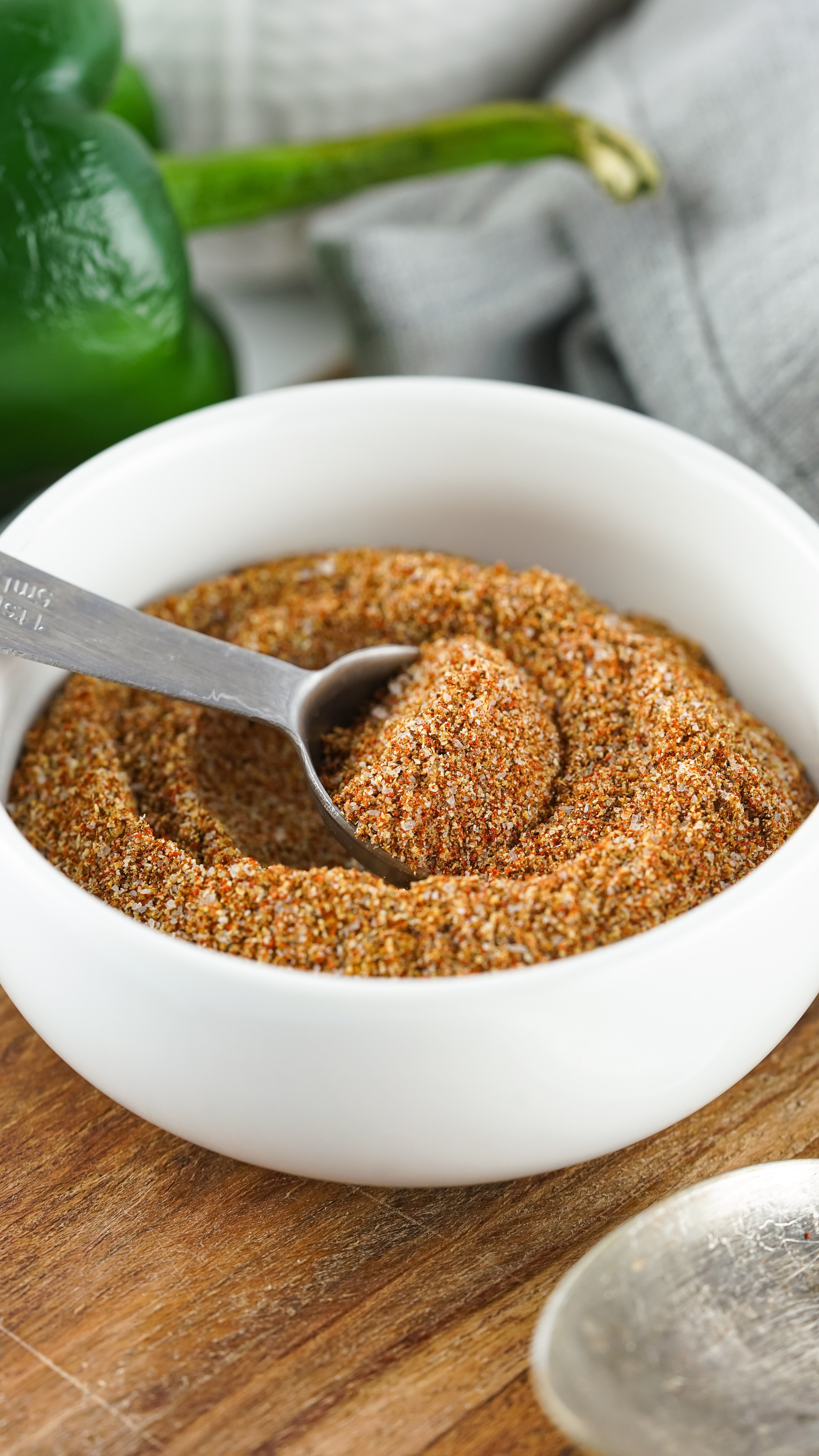 homemade fajita seasoning in a small white bowl on a wooden cutting board
