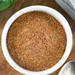 homemade fajita seasoning in a small white bowl on a wooden cutting board