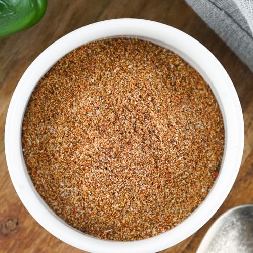 homemade fajita seasoning in a small white bowl on a wooden cutting board