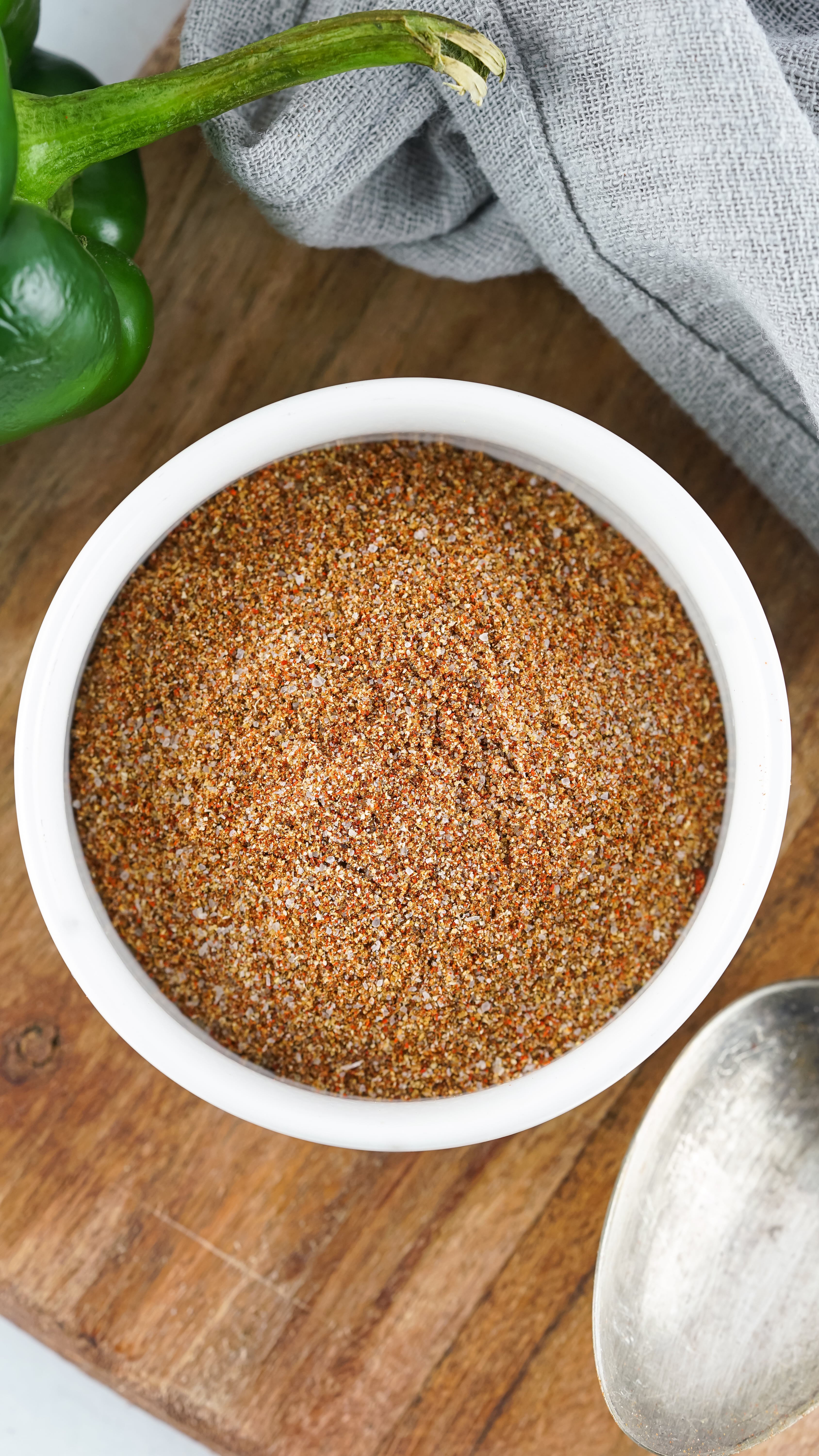homemade fajita seasoning in a small white bowl on a wooden cutting board