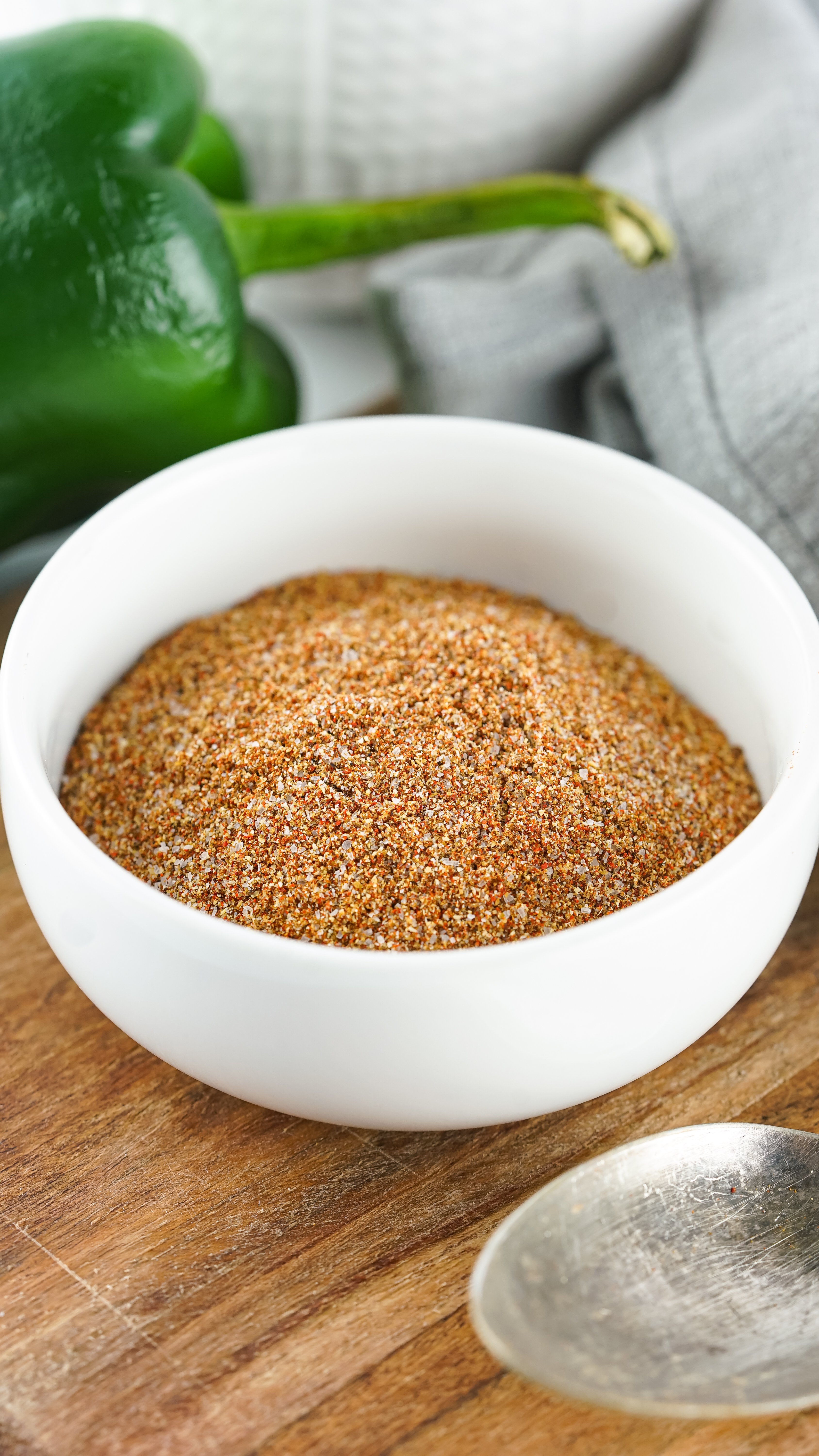 homemade fajita seasoning in a small white bowl on a wooden cutting board