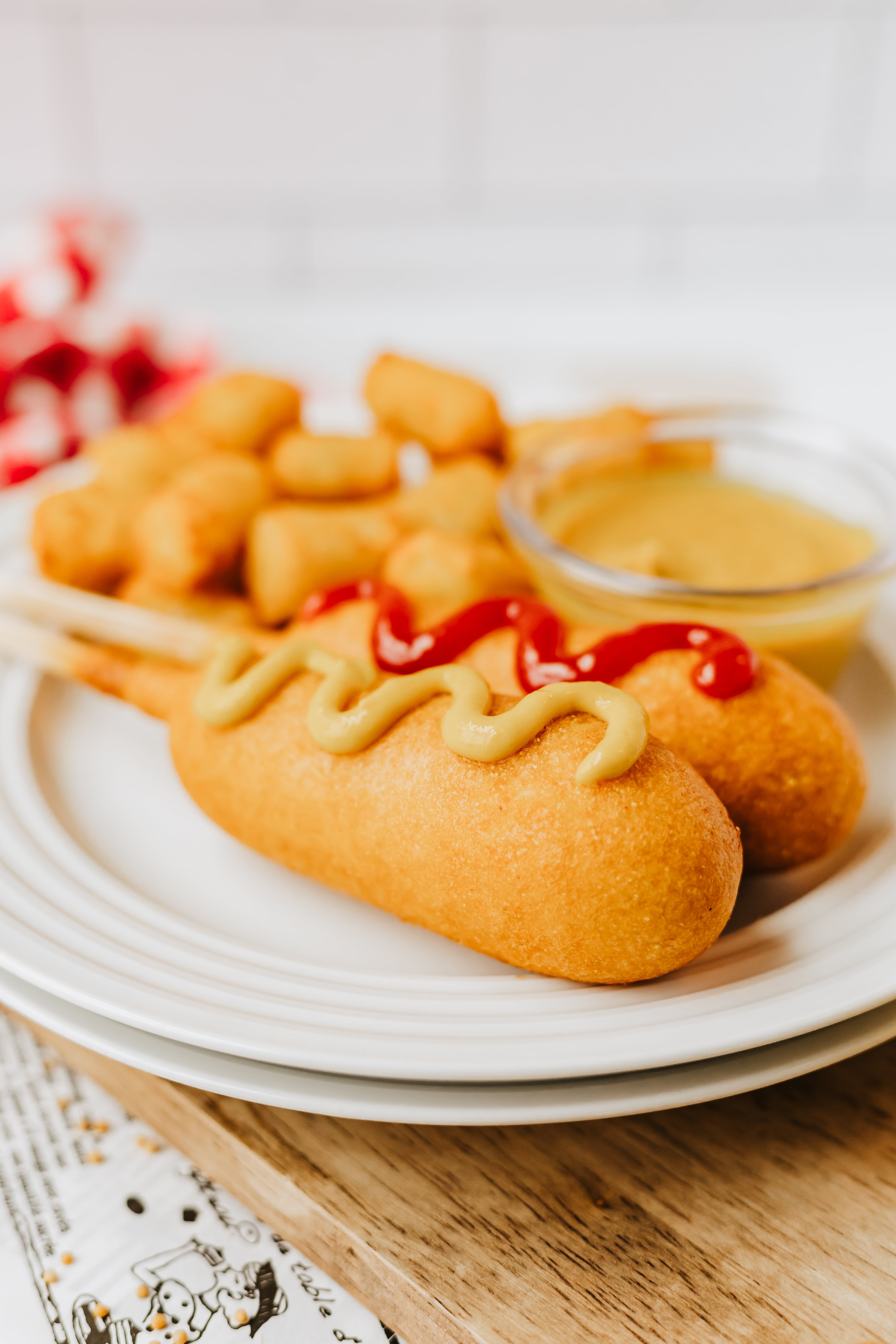 corndogs topped with a drizzle of homemade yellow mustard on a white plate