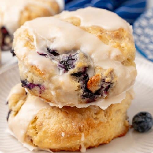two glazed bo-berry biscuits stacked on a small white plater