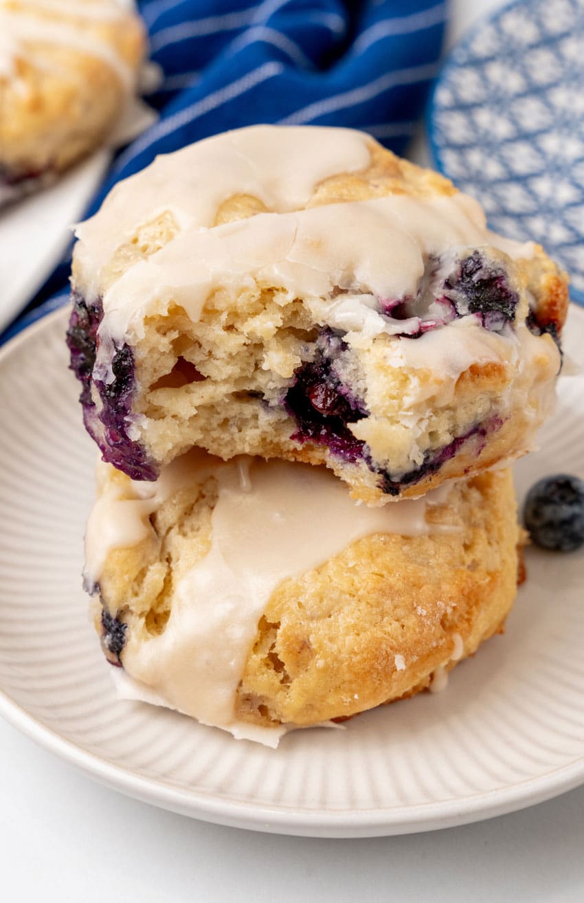two glazed bo-berry biscuits stacked on a small white plater
