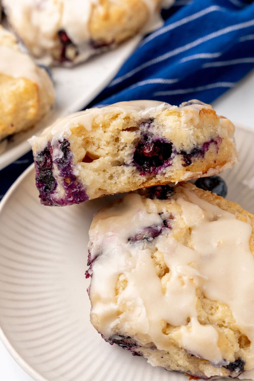 two glazed bo-berry biscuits stacked on a small white plater