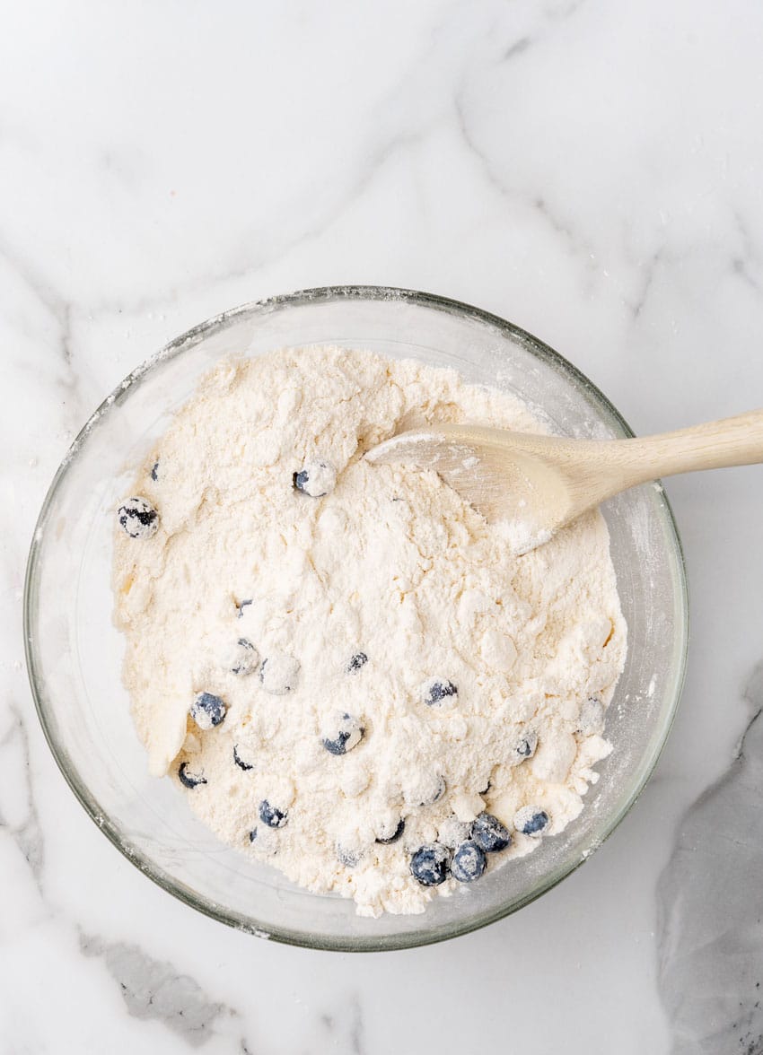 homemade blueberry biscuit batter in a glass mixing bowl