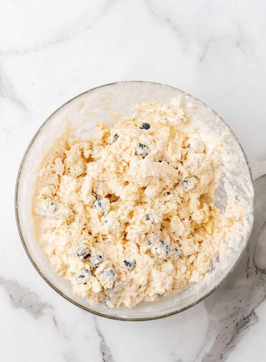 homemade blueberry biscuit batter in a glass mixing bowl