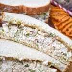 two halves of a chick fil a chicken salad recipe sandwich on a wooden cutting board