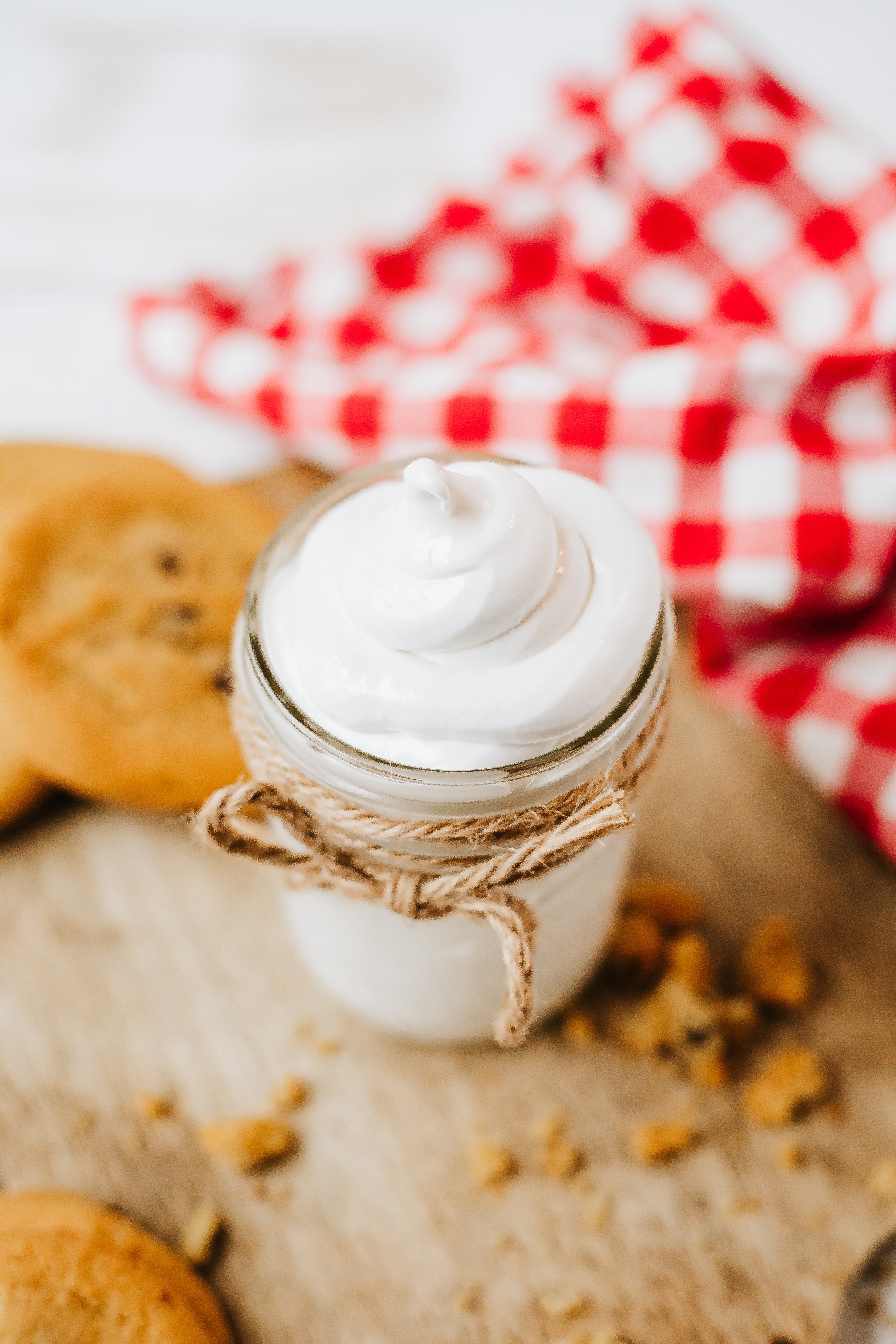 homemade marshmallow fluff in a glass jar on a wooden countertop