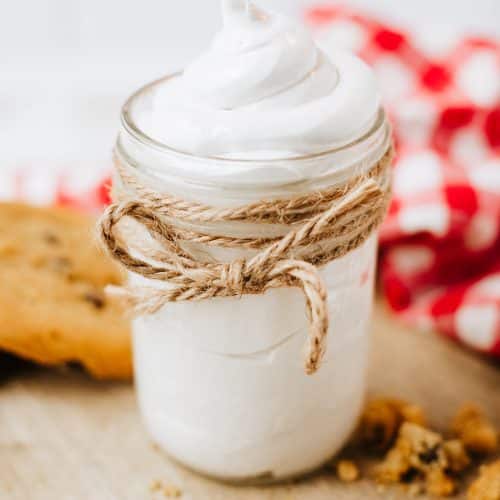 homemade marshmallow fluff in a glass jar on a wooden countertop