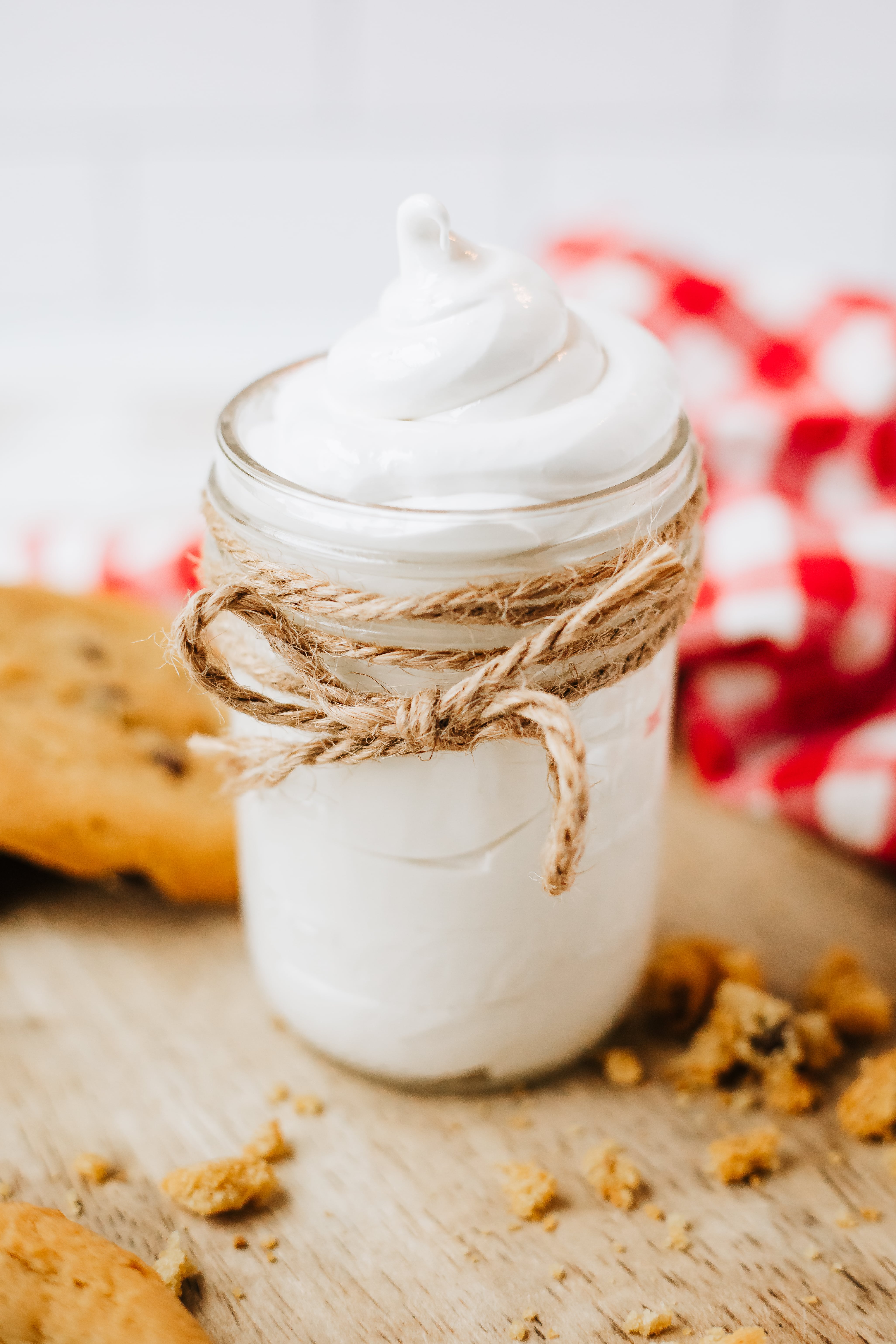 homemade marshmallow fluff in a glass jar on a wooden countertop