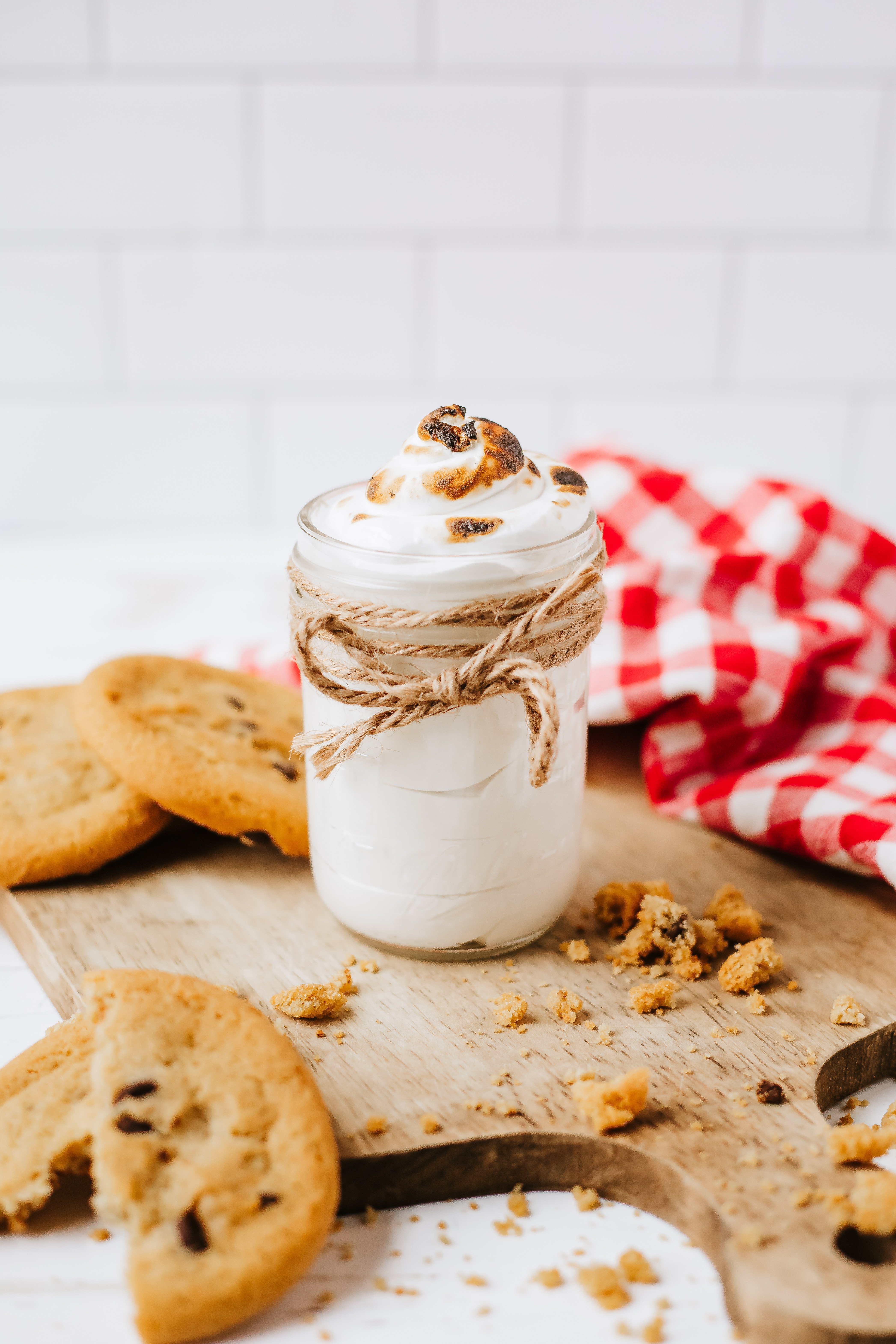 homemade marshmallow fluff in a glass jar on a wooden countertop