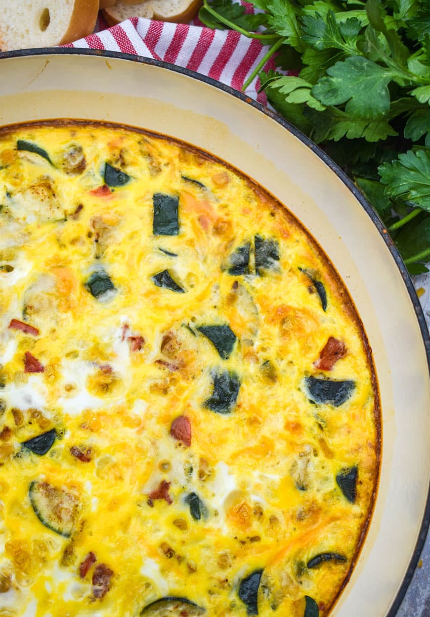 garden vegetable fritatta in a white cast iron skillet