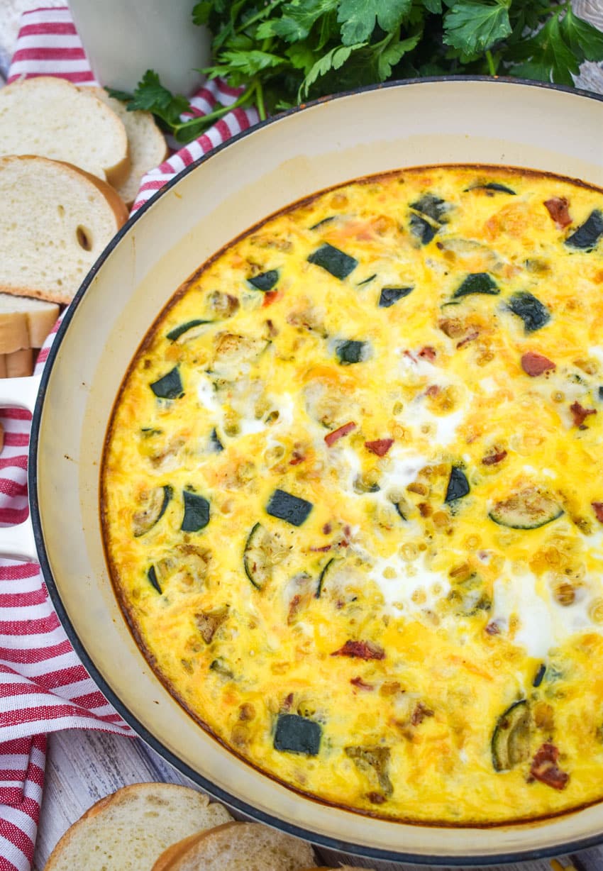 garden vegetable fritatta in a white cast iron skillet