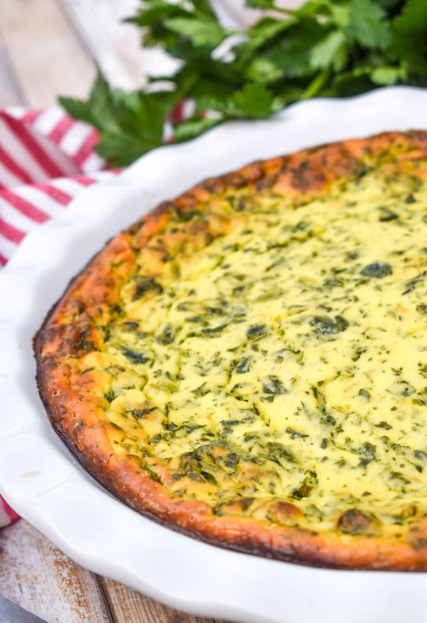 baked spinach ricotta pie in a white pie dish