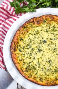 baked spinach ricotta pie in a white pie dish