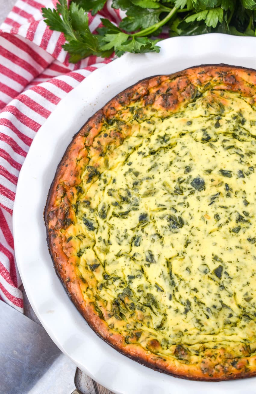 baked spinach ricotta pie in a white pie dish