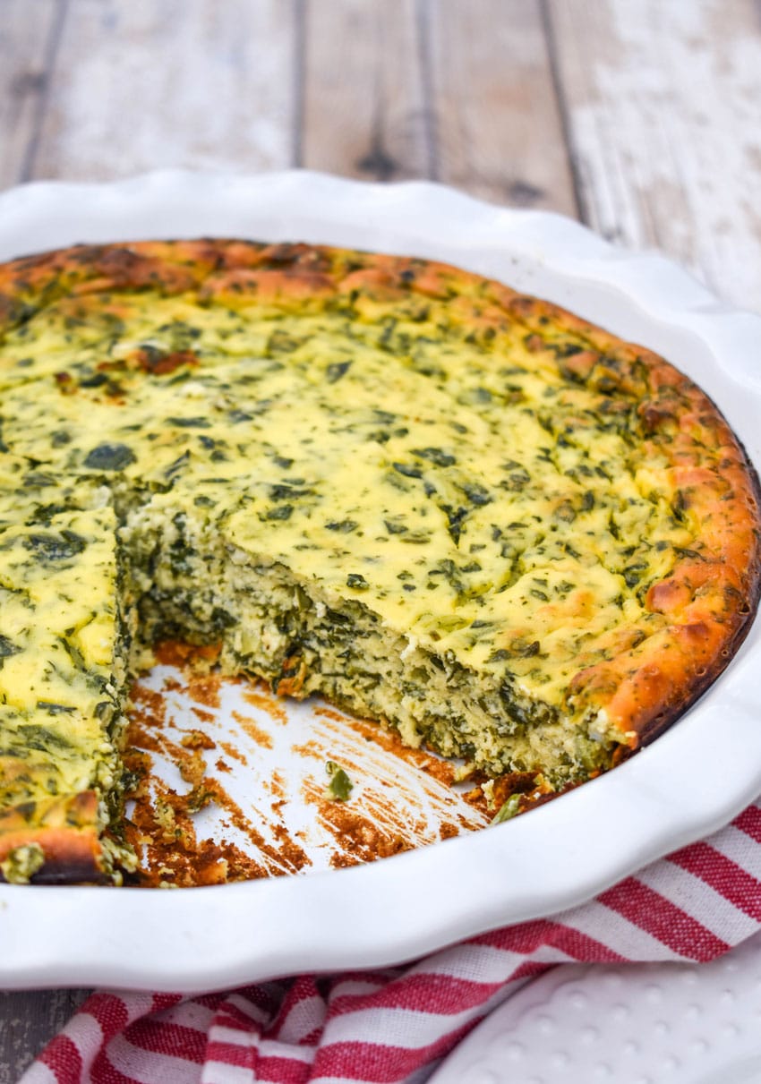 a spinach ricotta pie with slice removed to show the inner filling