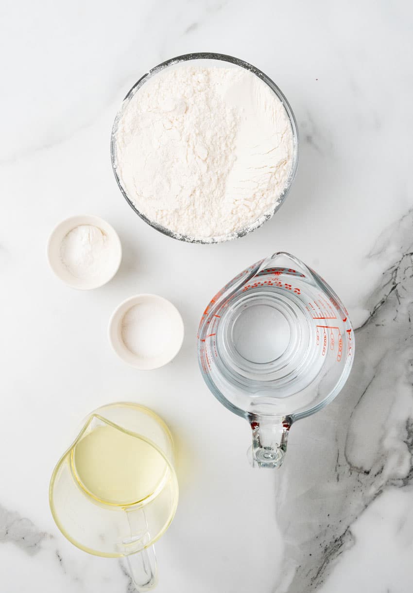 an overhead image showing the measured ingredients needed to make a batch of homemade flour tortillas